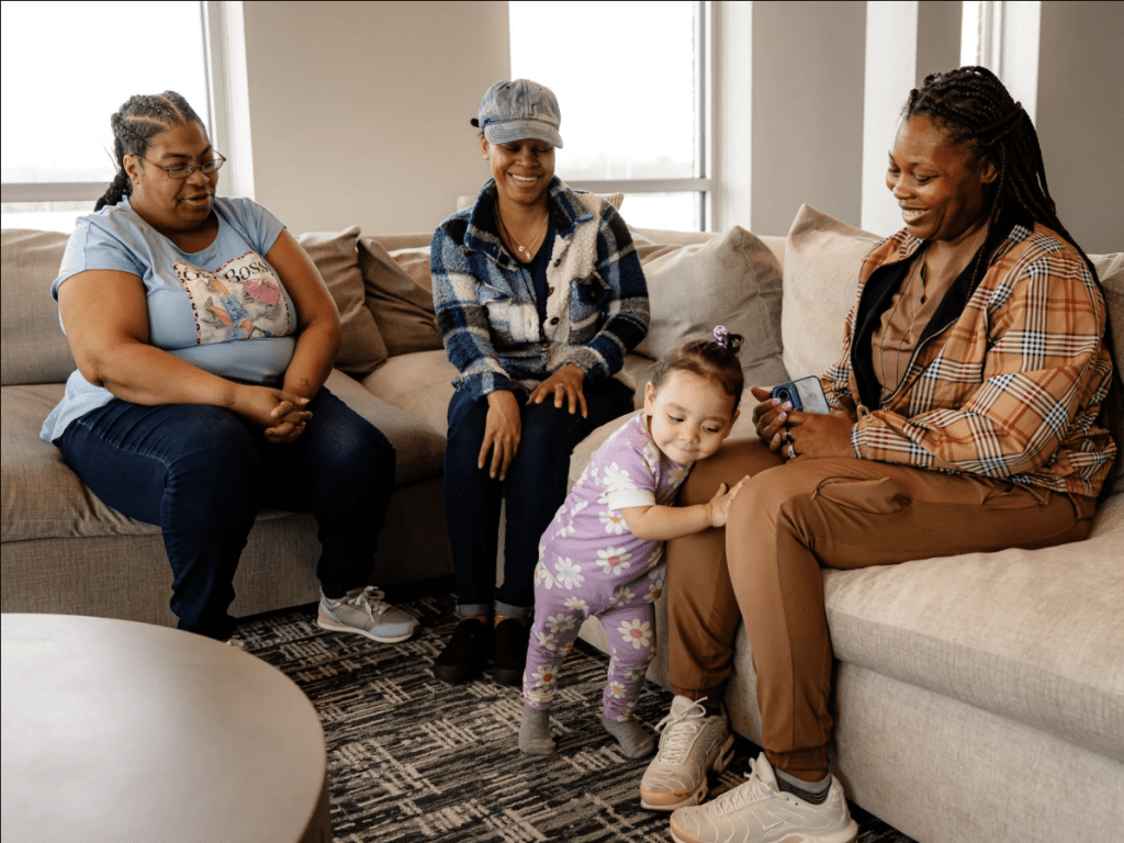 Decarya Andrews (left), a Raphah Institute graduate, sings to 1-year-old Stormy Jones along with Tihisha Jones and Markeisha Jones. Credit: Martin B. Cherry / Nashville Banner